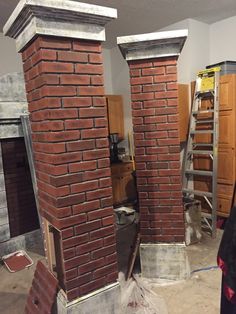 two brick fireplaces are being built in the middle of a room that is under construction