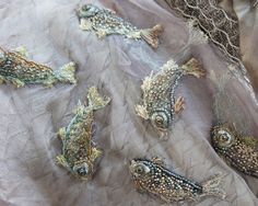 several different types of embroidered fish on fabric