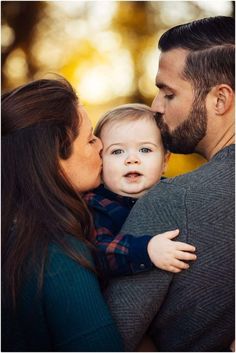 a man and woman holding a baby in their arms