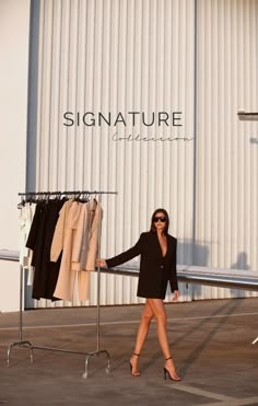 a woman standing in front of a clothing rack