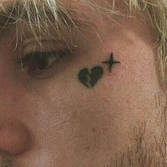 a man with a cross and heart tattoo on his forehead