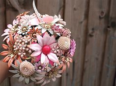 a bridal bouquet with pink and white flowers hanging from it's centerpiece