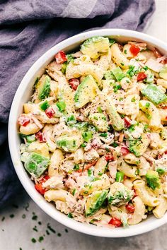 a white bowl filled with pasta salad on top of a table