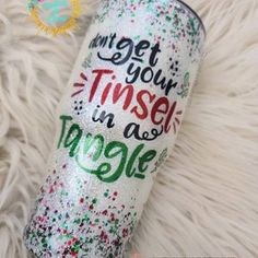 the tumbler has been decorated with glitter and confetti, which says get your tinsel in a cone