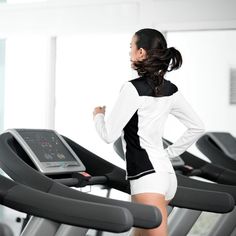 a woman running on a treadmill in a gym