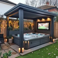 a hot tub sitting in the middle of a backyard next to a patio with lights on it