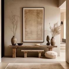 a table with two vases on top of it next to a bench and rug