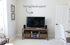 a flat screen tv sitting on top of a wooden entertainment center in a living room