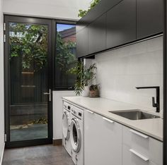 an image of a modern kitchen setting with washing machine and washer in the foreground