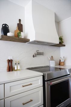 a stove top oven sitting inside of a kitchen next to a wall mounted range hood