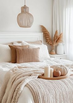 a bed with pillows and blankets on top of it next to a lamp hanging from the ceiling