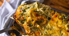 a close up of a spoonful of food on a pan with broccoli casserole