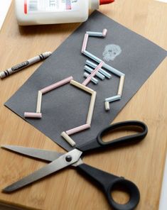 a cutting board with scissors, glue and other crafting supplies on top of it