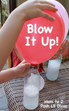 a person holding up a blow it up balloon with water and baking soda in it