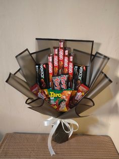 a bouquet of candy and candies in a box on a table with a ribbon