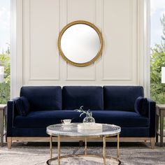 a living room with a blue couch and round mirror