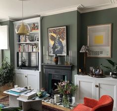 a living room filled with furniture and a fire place under a painting on the wall