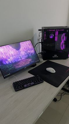 two computer monitors sitting on top of a wooden desk next to a keyboard and mouse