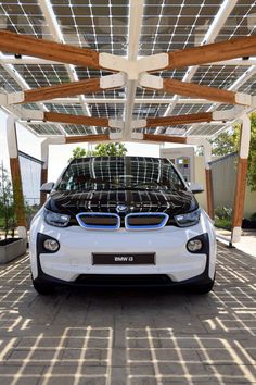 an electric car is parked under a roof with solar panels on it's sides