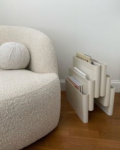 a white chair sitting next to a stack of magazines