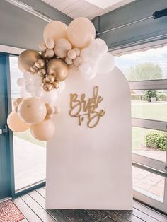 balloons are hanging from the side of a white wall that reads, bride to be