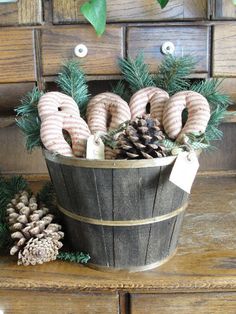 a wooden bucket filled with pine cones and pretzels on top of a table