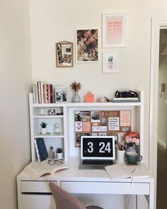 a white desk topped with a laptop computer next to a book shelf filled with books