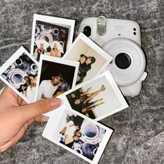 polaroid pictures are being held by a person's hand next to an instax camera