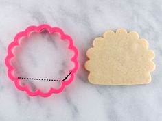 two cookie cutters sitting next to each other on a marble counter top, one with a scalloped edge