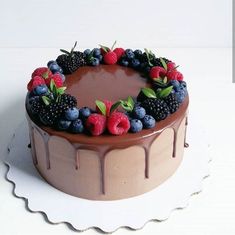 a chocolate cake topped with berries and raspberries