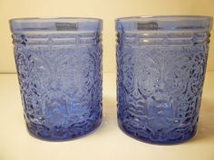 two blue glass cups sitting on top of a table