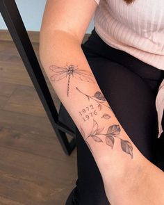 a woman with a dragonfly tattoo on her left arm and the words get out