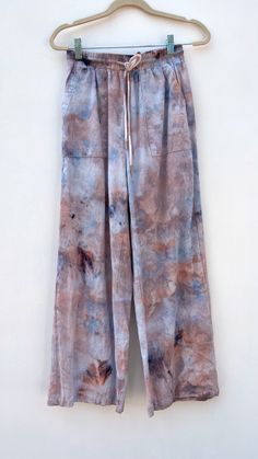 One of a kind hand ice dyed wide leg pants with drawstring & elastic waistband. 100% Cotton Individually ice dyed with non-toxic dyes. Prewashed - Wash with like colors in cold water & tumble dry low. What is Ice Dyeing? It’s a form of dying clothes were the fabric is first covered in ice, then the dye is applied on top. As the ice melts it creates a OOAK watercolor effect. This item was a fast fashion closeout style saved from its most likely future of incineration or the landfill and given a second chance at a new colorful life! Size US Hip Size Inseam Length Thigh Waist Size XS 2 38.6 27.8 40.2 25 24-36.2 S 4 40.2 28 40.6 26 25.2-37.8 M 6 41.7 28.1 40.9 26.9 26.4-39.4 L 8/10 44.1 28.1 41.1 28.4 28.3-41.7 Wide Leg Drawstring Pants, How To Dye Shoes, Handwoven Tapestry, Colorful Life, Ice Dyeing, Second Chance, Top Gifts, Drawstring Pants, British Indian