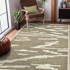 a living room area with a chair, rug and potted plant on the floor