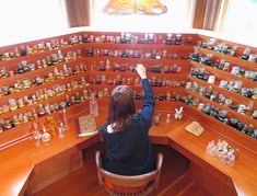 a woman sitting at a desk with lots of bottles on it