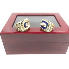 two gold rings sitting on top of a wooden box