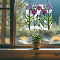 a potted plant sitting on top of a window sill next to a stained glass window