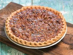 a pecan pie sitting on top of a wooden cutting board