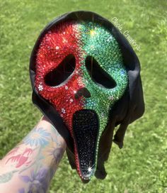 a person wearing a colorful mask with their face painted red, green and blue in the shape of a skull