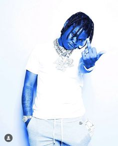 a man with blue paint on his face making the peace sign while standing against a white wall