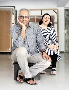 an older man sitting on a bench next to a young woman in a room with doors