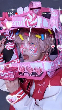 a girl with her face painted in pink and white is holding up a candy machine