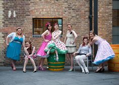 a group of women posing for a photo in front of a brick building