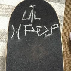 a skateboard with writing on it sitting next to a computer mouse