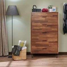 a wooden dresser sitting next to a lamp on top of a hard wood floor