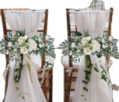 two chairs decorated with white flowers and greenery