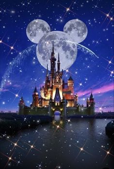 the castle is lit up at night with stars in the sky