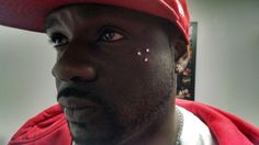 a close up of a person wearing a red hat with white dots on his face