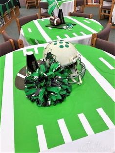 a football helmet and pom - poms are sitting on top of a table