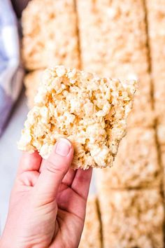 a hand holding up a cracker that has some kind of food on it,